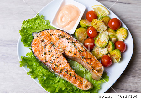 Grilled salmon with brussels sprouts and tomatoes 46337104