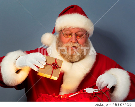 Santa Claus putting gifts into his sack 46337419
