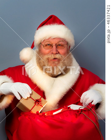 Santa Claus putting gifts into his sack 46337421