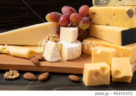 Various types of cheese on a rustic table 46345355