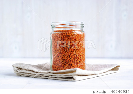 Glass jar filled with orange or red lentils 46346934