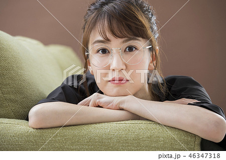 ソファに寝そべる眼鏡の女性 46347318