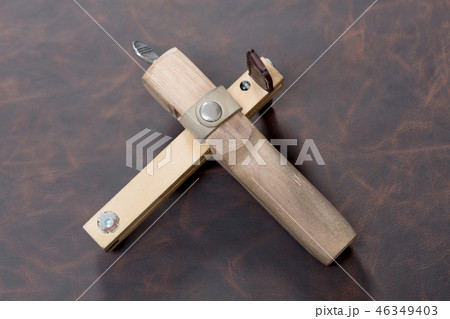 The strap cutter on brown leather background. 46349403