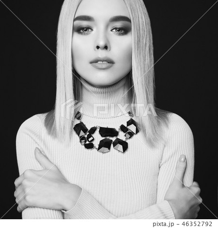 Beautiful young blonde with classic makeup and modern jewelry