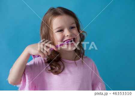 little girl brushing his teeth with a toothbrush dent 46353310