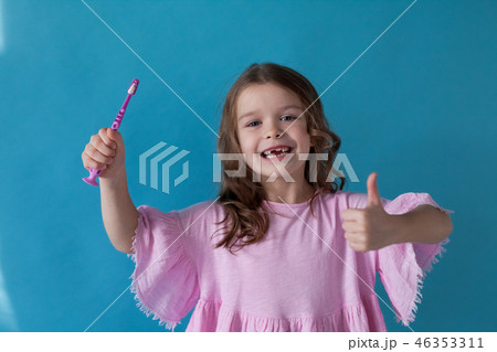 little girl brushing his teeth with a toothbrush dent 46353311