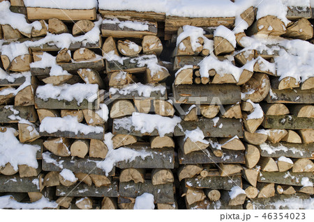 Chopped firewood on a stack in snow. Front view. 46354023