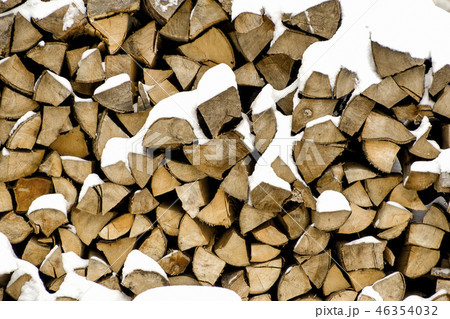 Chopped firewood on a stack in snow. Front view. 46354032