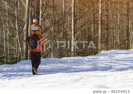 Man with son on shoulders walking along the road Man with son on shoulders walking along the road 46354053