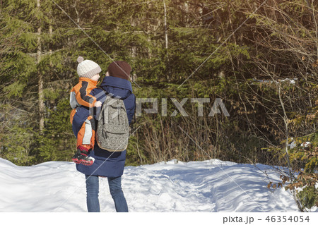 Mother with son in arms and backpack stands Mother with son in arms and backpack stands 46354054