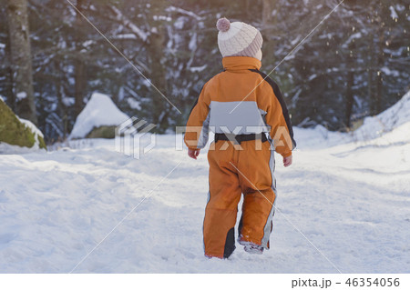 Little boy in an orange jumpsuit walking 46354056