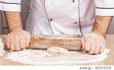 male cook kneads dough on the table 46354528