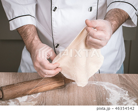 male cook kneads dough on the table male cook kneads dough on the table 46354542