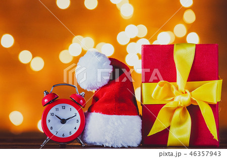 Christmas gift box and Santa Claus hat with red vintage alarm clock Christmas gift box and Santa Claus hat with red vintage alarm clock 46357943