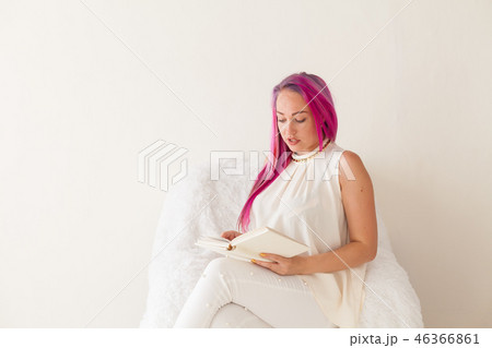 beautiful woman with pink hair reads the book learning 46366861