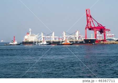 桟橋に接岸する大型貨物船とタグボート 桟橋に接岸する大型貨物船とタグボート 46367711