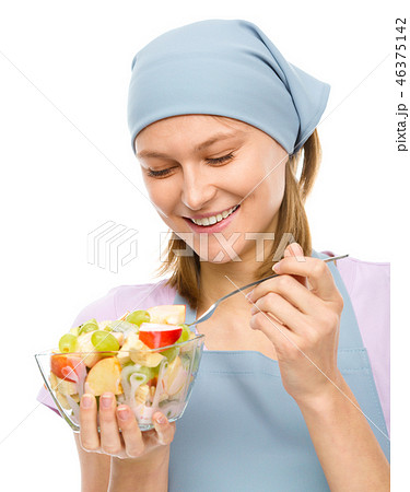 Young attractive woman is eating salad using fork Young attractive woman is eating salad using fork 46375142