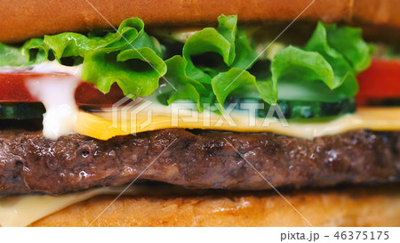 Yummy fast food concept. Fresh homemade grilled burger with meat patty, tomatoes, cucumber, lettuce 46375175