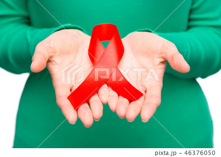 Woman is holding the red awareness ribbon Woman is holding the red awareness ribbon 46376050