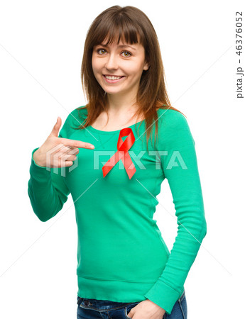 Woman is pointing to the red awareness ribbon Woman is pointing to the red awareness ribbon 46376052
