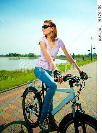 Young woman is sitting on her bicycle Young woman is sitting on her bicycle 46376406