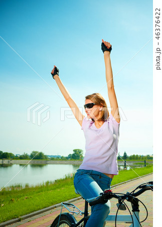 Young woman is sitting on her bicycle Young woman is sitting on her bicycle 46376422