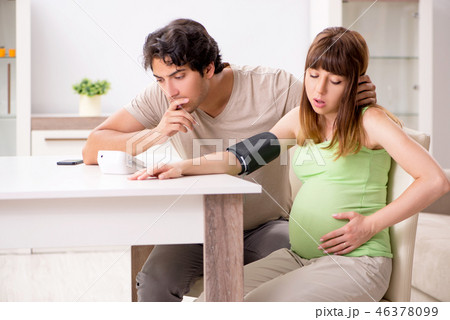 Husband checking pregnant wife's blood pressure Husband checking pregnant wife's blood pressure 46378099