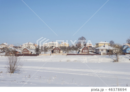 Winter landscape, village by frozen river 46378694