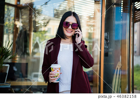 Portrait pretty girl with dark hair in Burgundy fur coat of artificial fur. She looks excited and 46382158
