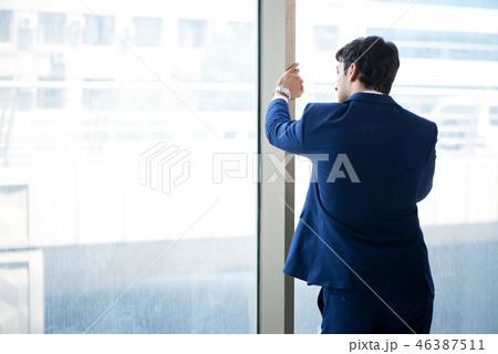 Young handsome businessman standing at the window Young handsome businessman standing at the window 46387511