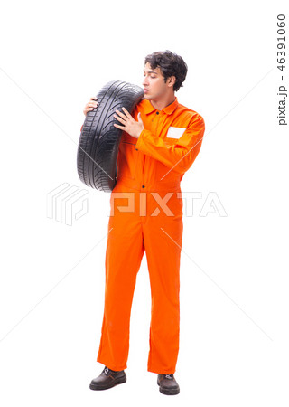 Young garage worker with tyre isolated on white Young garage worker with tyre isolated on white 46391060