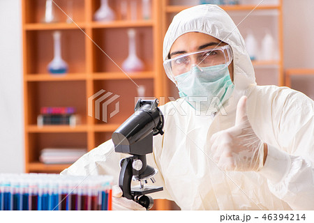 Young biochemist wearing protective suit working in the lab Young biochemist wearing protective suit working in the lab 46394214