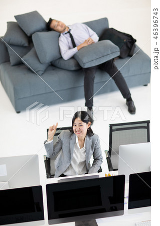 Woman working, man napping at work. Woman working, man napping at work. 46396743