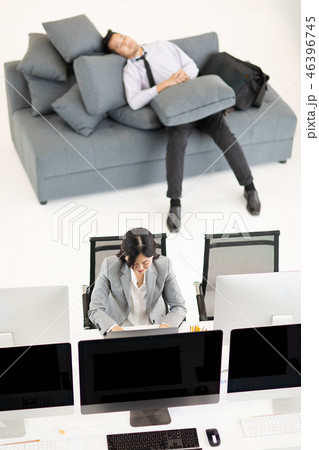 Woman working, man napping at work. Woman working, man napping at work. 46396745