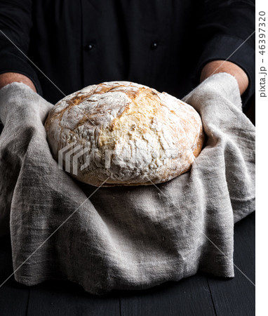 baked round homemade bread on a gray napkin baked round homemade bread on a gray napkin 46397320