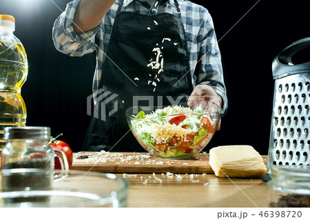 Preparing salad. Female chef cutting fresh vegetables. Cooking process. Selective focus 46398720