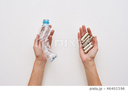 Sparate your trash. Two human hands are holding plastic and batteries isolated Sparate your trash. Two human hands are holding plastic and batteries isolated 46401596