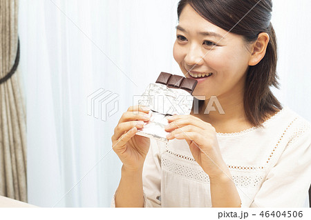 板チョコを食べる女性の写真素材