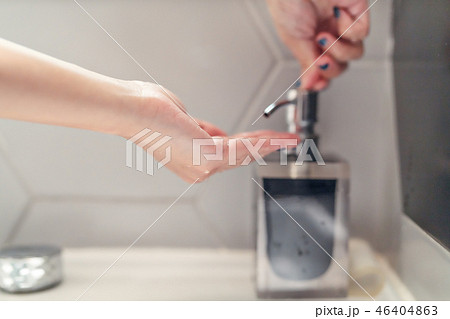 women washing hand with liquid soap in restroom 46404863