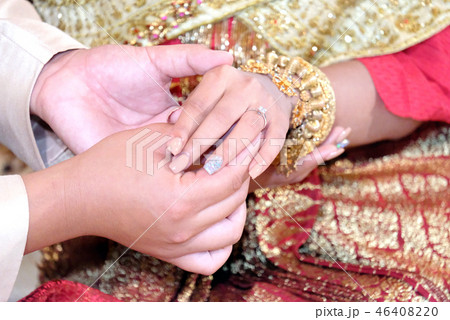 Thai wedding groom putting a ring on finger. Thai wedding groom putting a ring on finger. 46408220