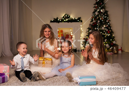 the little boy and three girls open Gifts Christmas new year tree Garland the little boy and three girls open Gifts Christmas new year tree Garland 46409477