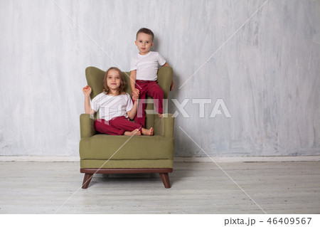 the little boy and girl sit together in a green Chair the little boy and girl sit together in a green Chair 46409567