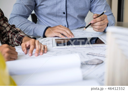 Construction engineering or architect discuss a blueprint while 46412332