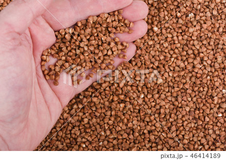 A handful of buckwheat over a background of buckwheat 46414189