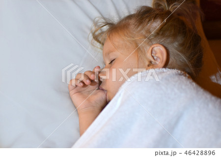 The child sucks a finger in bed The child sucks a finger in bed 46428896