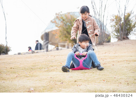 冬の公園で芝滑りをする子供 46430324
