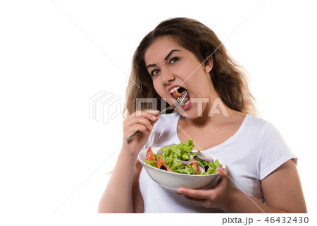 Hungry teen girl eating the salad with funny face 46432430