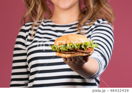 cropped photo of smiling girl showing hamburger 46432439