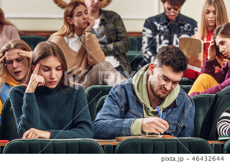 The group of cheerful happy students sitting in a lecture hall before lesson The group of cheerful happy students sitting in a lecture hall before lesson 46432644