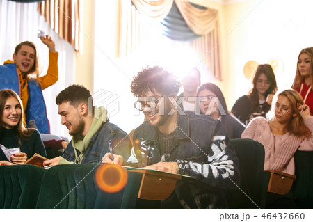 The group of cheerful happy students sitting in a lecture hall before lesson The group of cheerful happy students sitting in a lecture hall before lesson 46432660